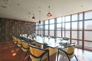 A conference room with a long table, chairs, and pendant lighting. - Wyndham Grand Yangon (Yangon)