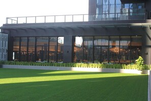 A modern building with large glass windows, a flat roof, and a well-maintained lawn. - Wyndham Grand Yangon (Yangon)