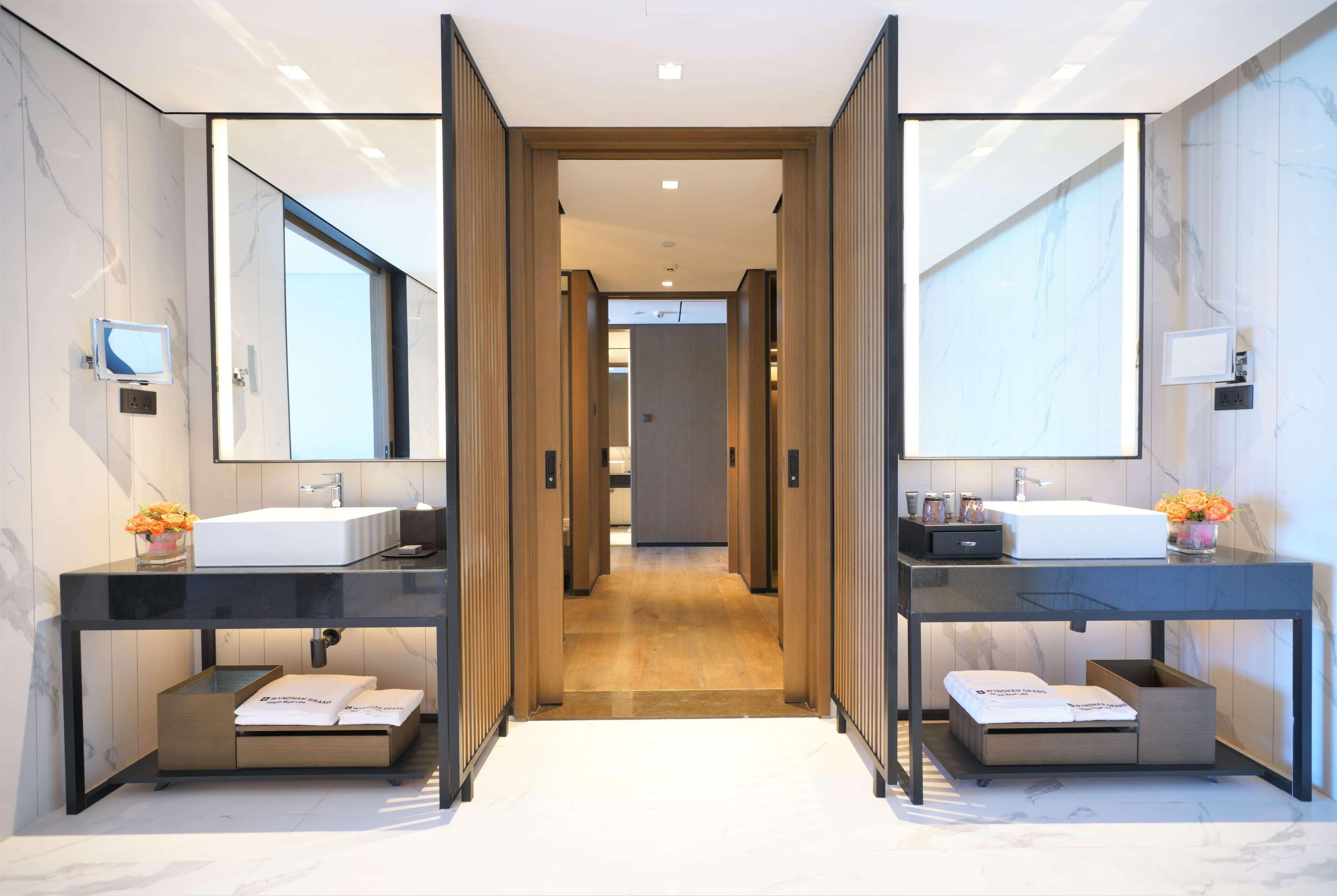 Un bagno moderno con due lavabi, uno specchio grande e un mobile bagno in legno.