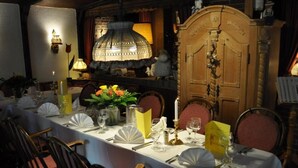 A dining table set with white tablecloth, candles, and floral centerpieces. - Bei Hölzchen (Hannover)