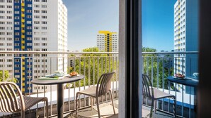 Un balcón con una mesa, sillas y vistas de edificios altos.