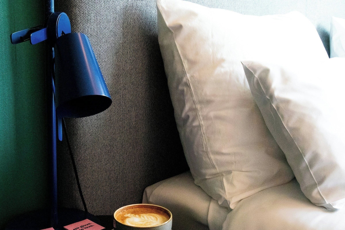 A cup of coffee on a saucer with a napkin and a sign that says "No glove. No love." next to it.