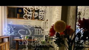 Een kamer met een houten tafel, een bloemenvaas en een kamerbreed tapijt.