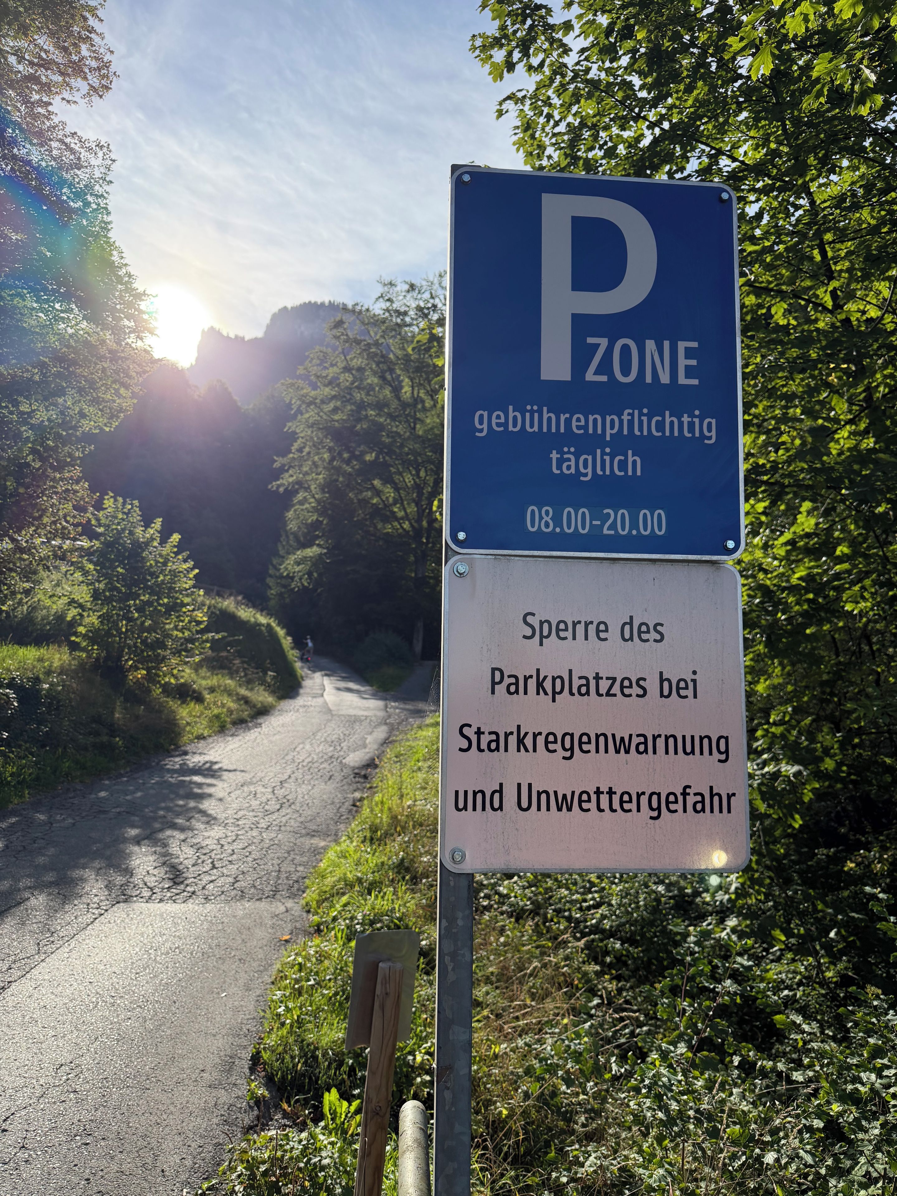 Un panneau de signalisation indiquant un espace de stationnement, avec un fond bleu et un texte blanc, précisant les heures d’utilisation de cet espace.
