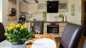 Een moderne keuken met een ingebouwde oven, een koffieapparaat en een flatscreen televisie.