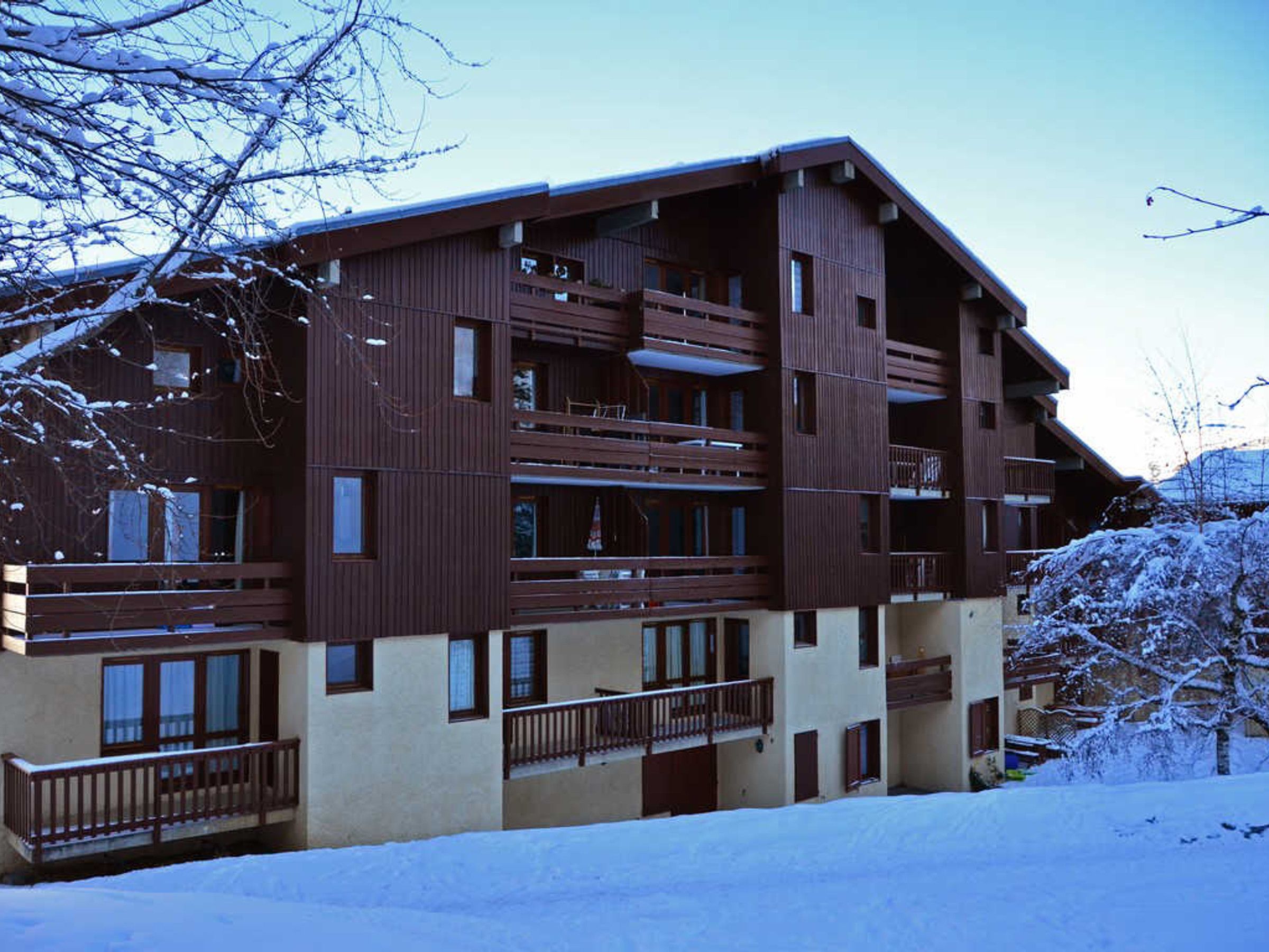 Un edificio de varios pisos con balcones y ventanas grandes, rodeado de nieve.