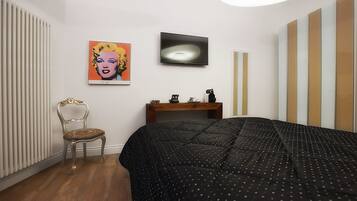 A bedroom with a bed, a chair, a desk, a radiator, and a painting on the wall.