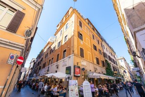 A bustling street with outdoor seating at a restaurant, a McDonald's sign, and a building with a visible number '8'. - Domus De' Fiori (Rome)
