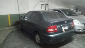 A parking garage with a dark-colored car parked in a space. - Gascon MDQ by BonRent (Mar del Plata)