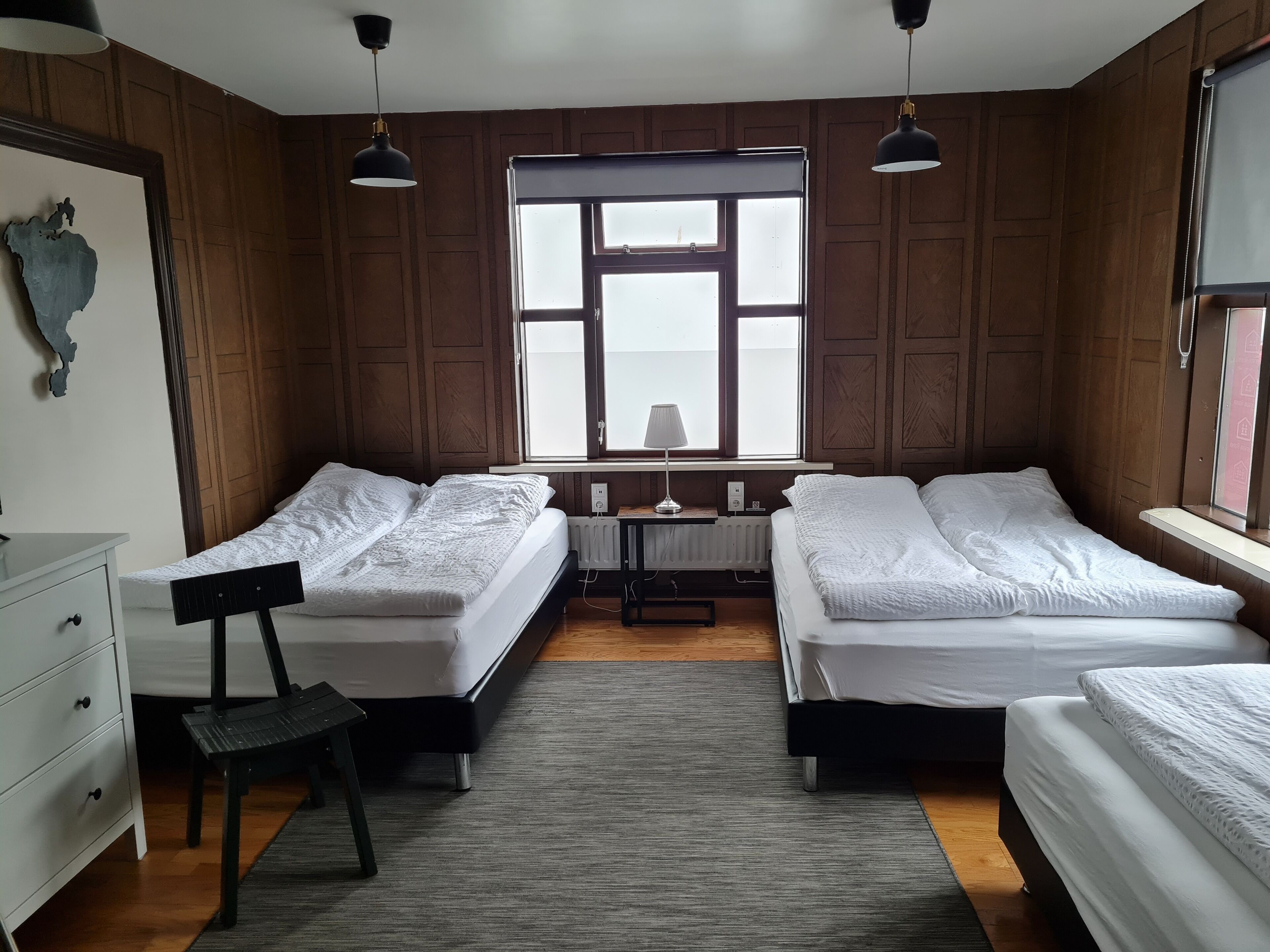 A room with two beds, a desk, and a chair.