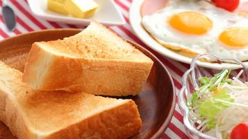 A breakfast setting with toast, eggs, butter, and a salad.