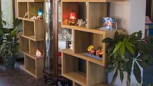 Una estantería de madera con varios objetos decorativos y un aparador de vidrio.
