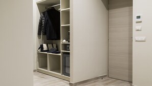 A modern hallway with a built-in closet, a door with a control panel, and a light-colored wooden floor. - Borghetto Guest House (Rome)