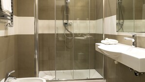 A modern bathroom with a glass-enclosed shower, two sinks, and a large mirror. - Borghetto Guest House (Rome)