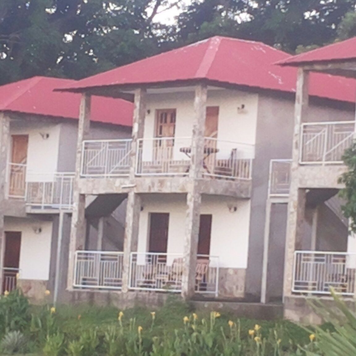 Un edificio de varios pisos con balcones y un techo rojo.