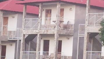 Un edificio de varios pisos con balcones y un techo rojo.