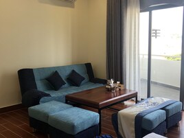 Ένα μοντέρνο σαλόνι με έναν καναπέ, πουφ και ένα τραπεζάκι σαλονιού.