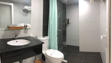 Ein Badezimmer mit einem schwarzen Waschbecken, einer weißen Toilette und einer Duschkabine aus Glas.