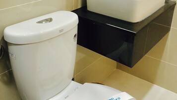 Ein Badezimmer mit Toilette, Waschbecken und Spiegel.