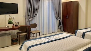 A hotel room with two beds, a desk with a chair, a television, and a wardrobe. - Victory Airport Hotel (Ho Chi Minh City)