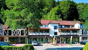 Un hotel de estilo arquitectónico europeo tradicional, con tejado de tejas rojas y una estructura de dos pisos.