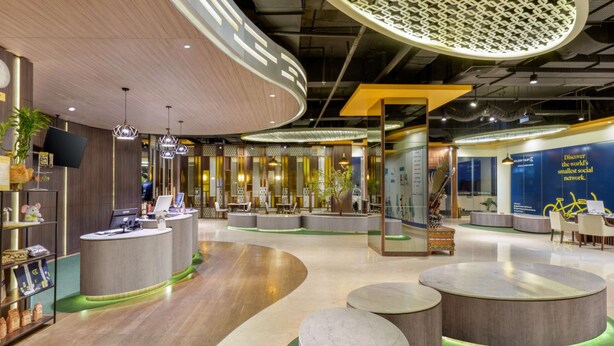 Un intérieur moderne comprenant un comptoir d’accueil, des espaces d’attente et des éléments décoratifs.