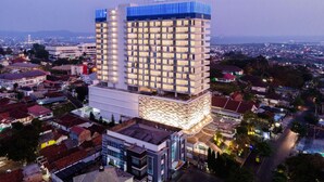 Un hôtel de grande hauteur au design moderne, reconnaissable à son enseigne imposante située en haut de l’édifice.