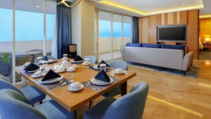 Une chambre d’hôtel moderne avec un coin repas, un canapé et une télévision.