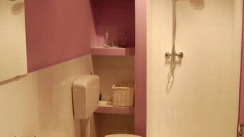 A bathroom with a sink, toilet, and shower.