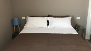 Une chambre à coucher avec un grand lit, une lampe bleue et un radiateur.
