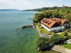 A lakeside property with a large house, dock, and boats.