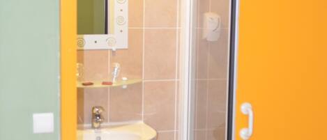 Un bagno con lavandino, specchio e doccia.