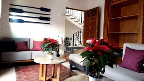 A living room with a sofa, two armchairs, a coffee table, and two potted plants. - Casa Carmen - Boutique B&B (Puerto Vallarta)