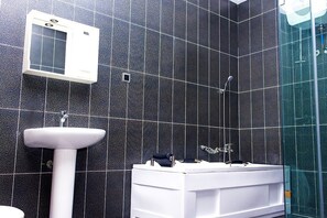 Deluxe villa | Badkamer | Een diep bad, een regendouche, gratis toiletartikelen, een haardroger