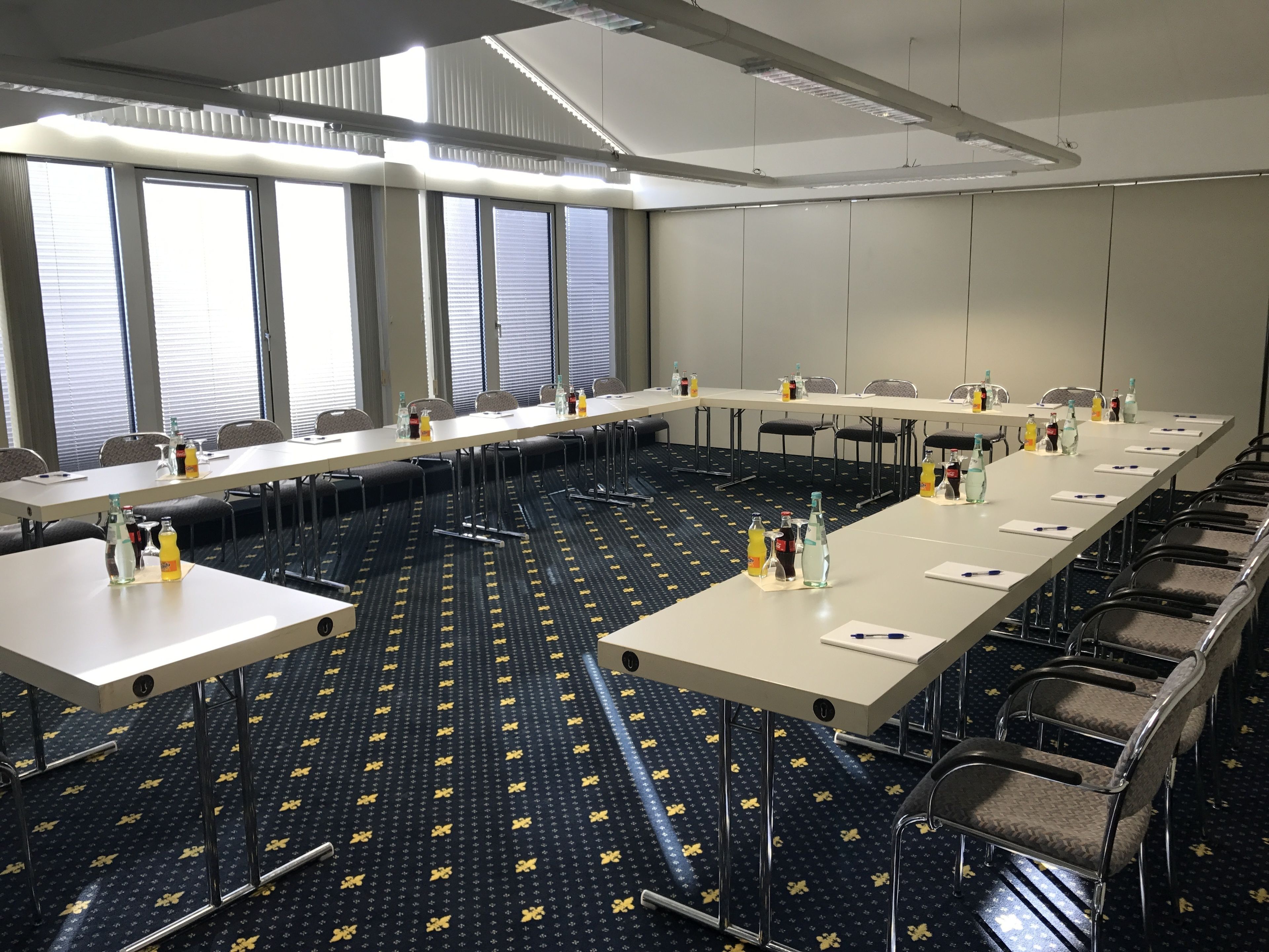 A conference room with long tables, chairs, and water bottles.