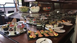 A buffet with various food items including salads, fruits, and meats. - Karaman Group Hotel (Bad Nenndorf)