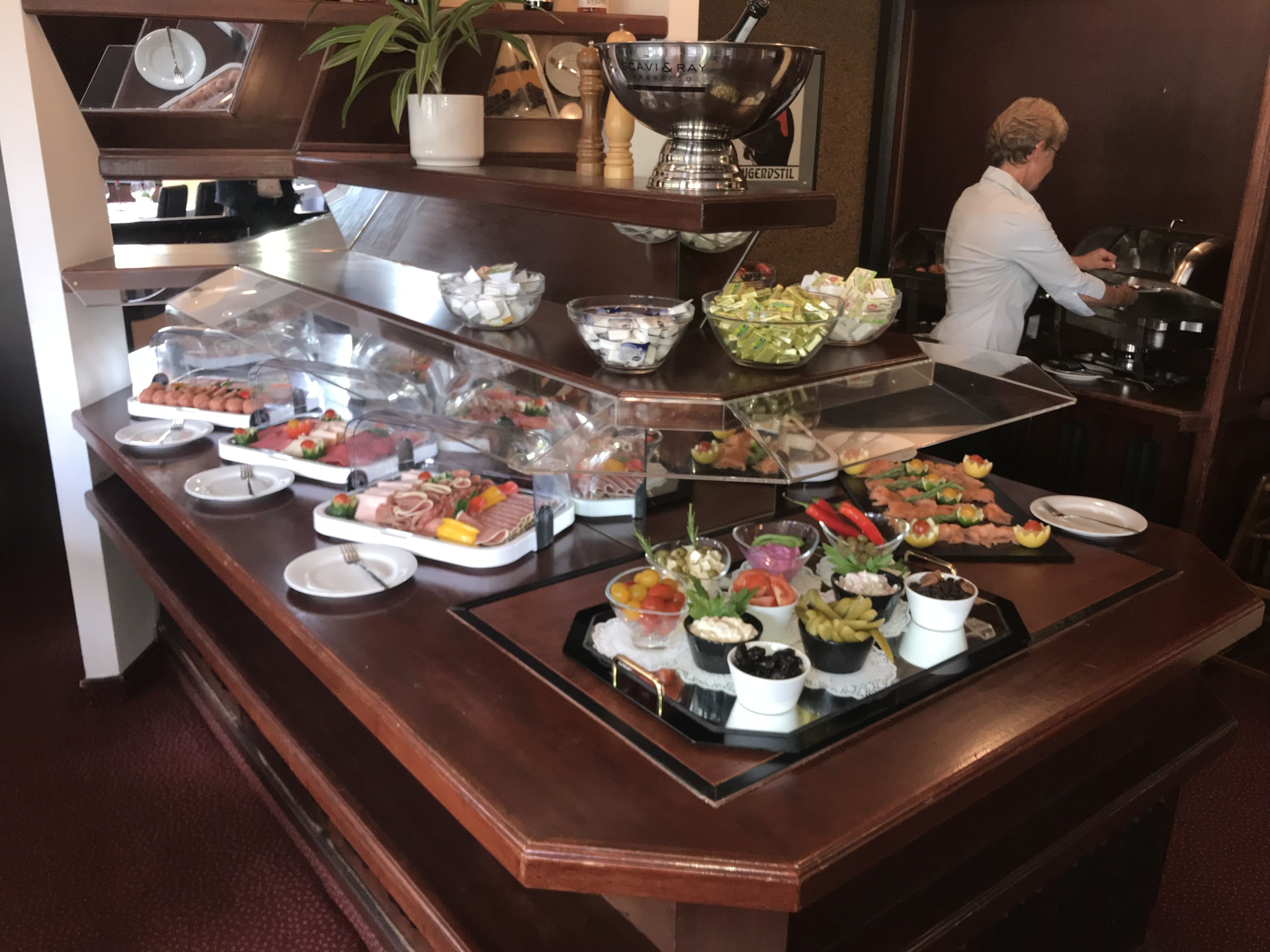 Buffet amb diversos aliments, com ara carns, formatges i verdures.