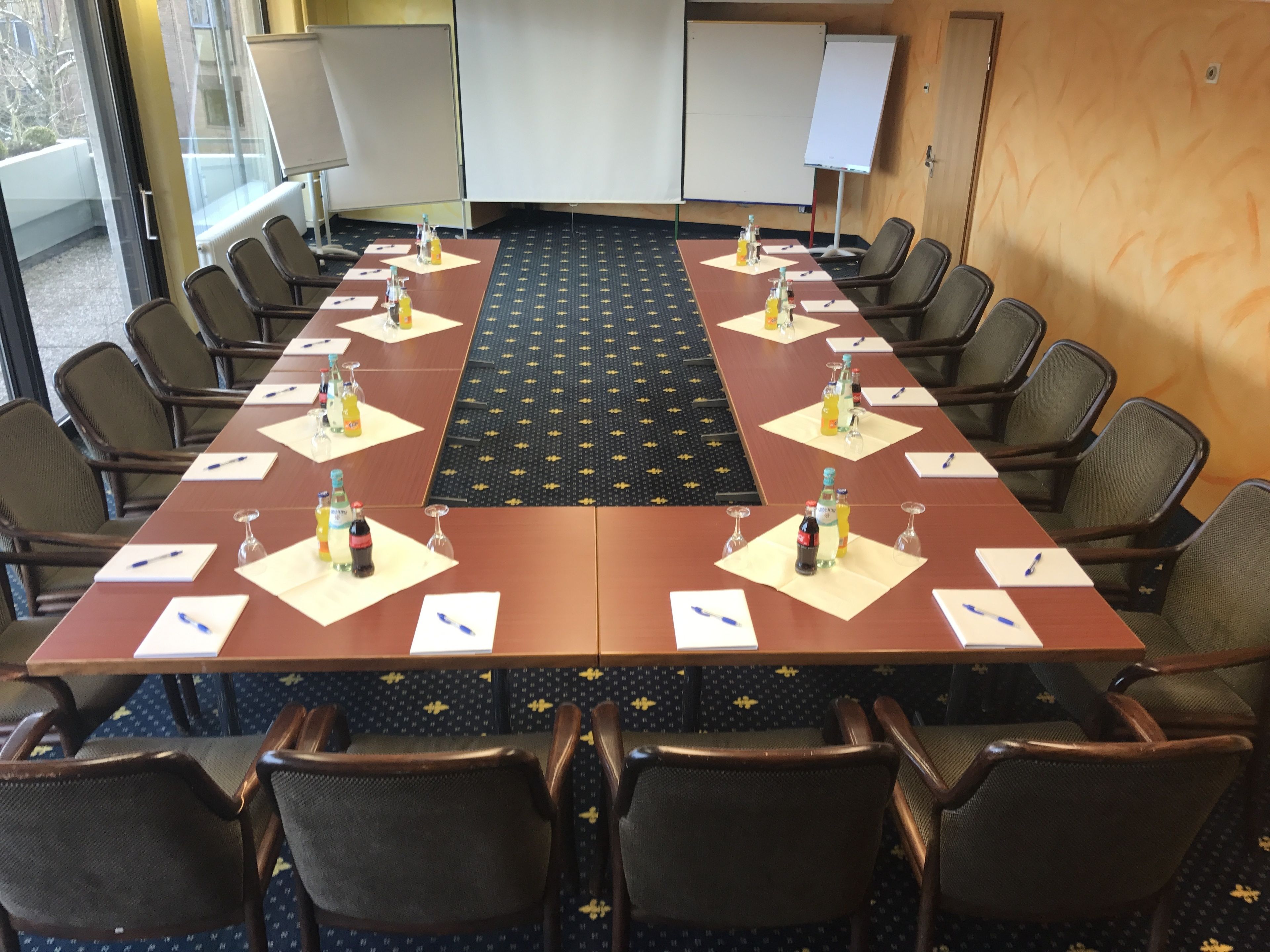 A conference room with a long table, chairs, and whiteboards.