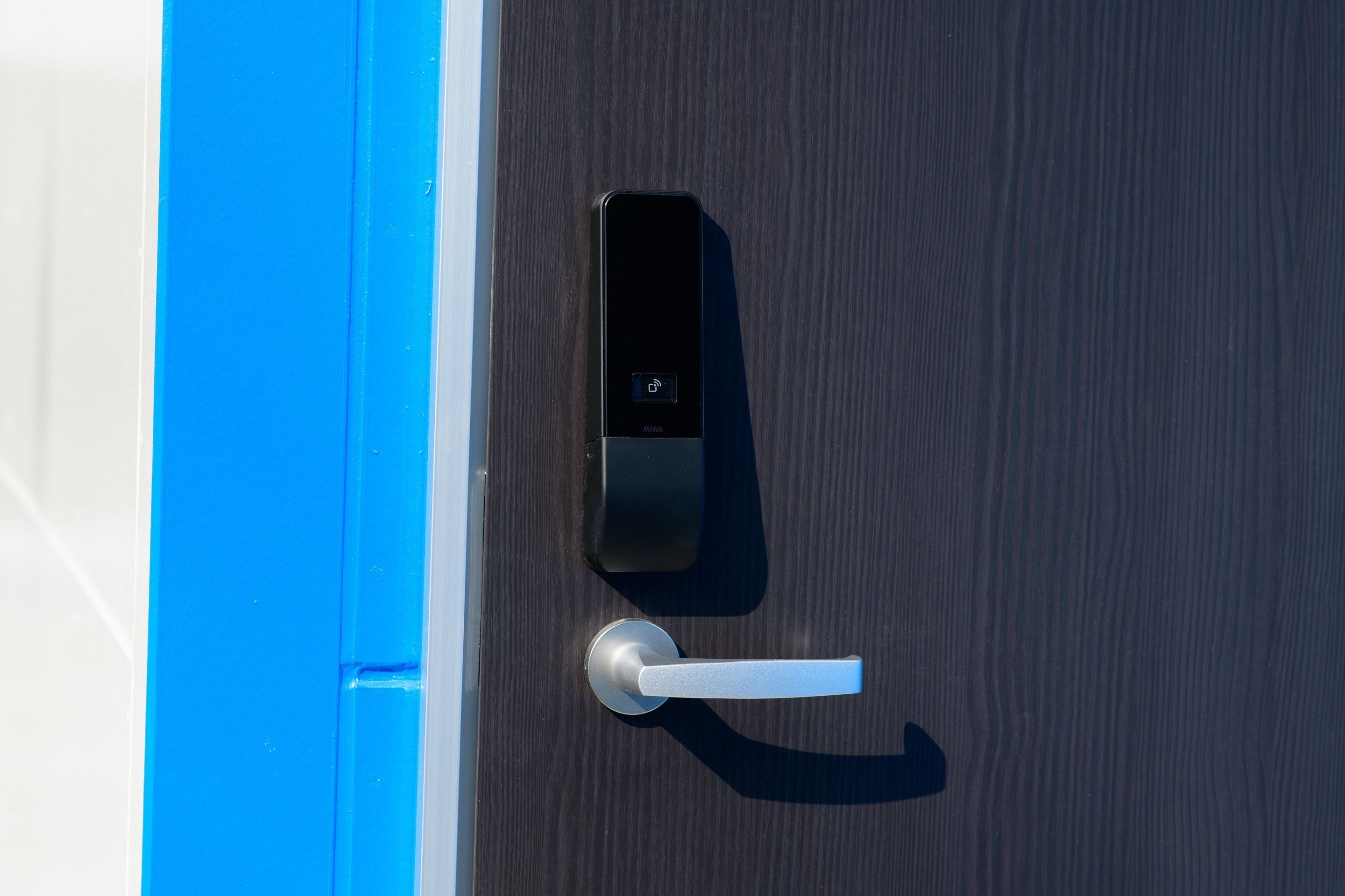 A modern door with a digital lock and a keyhole.
