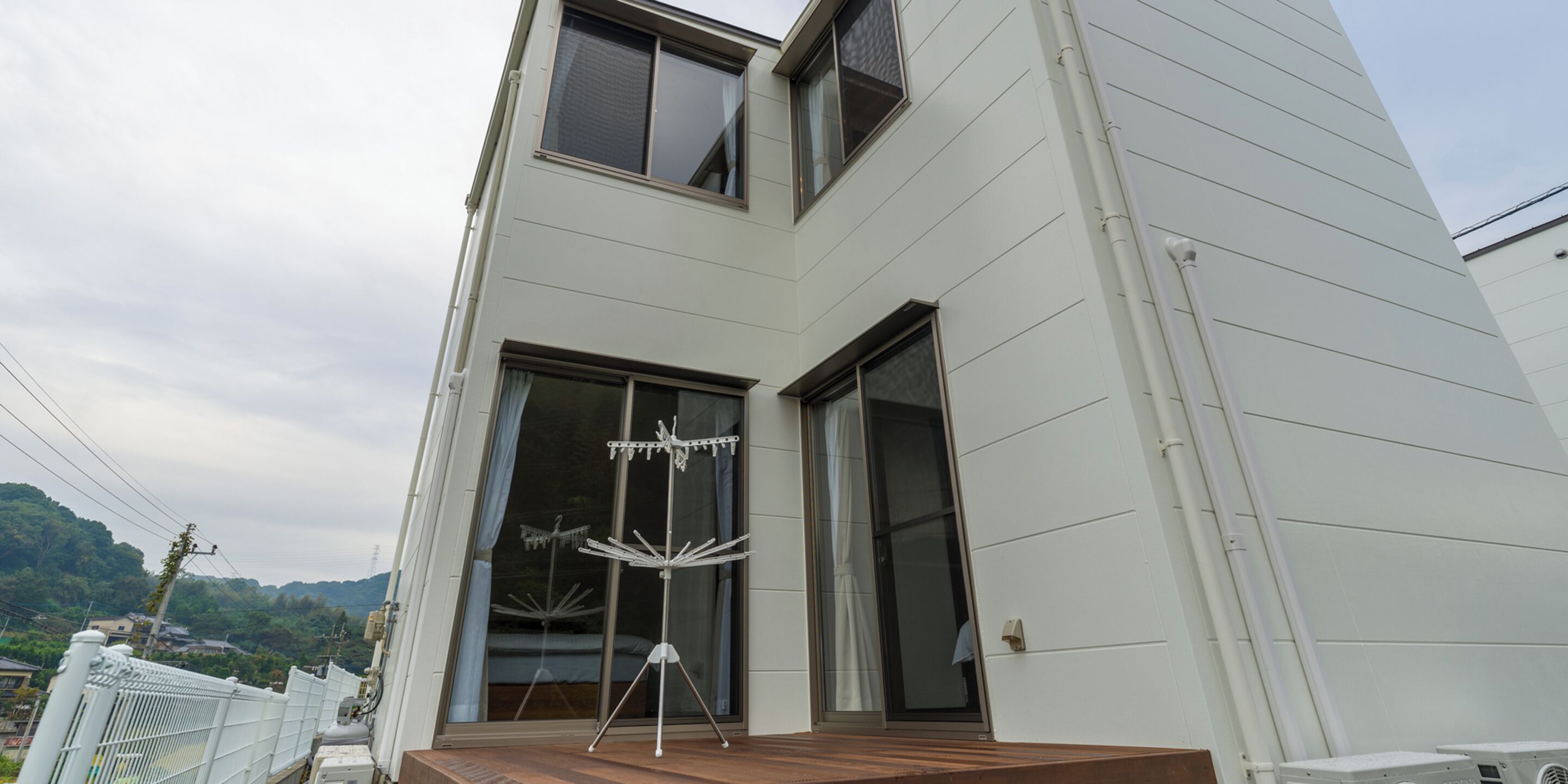 A modern building with a large glass door and a wooden deck.
