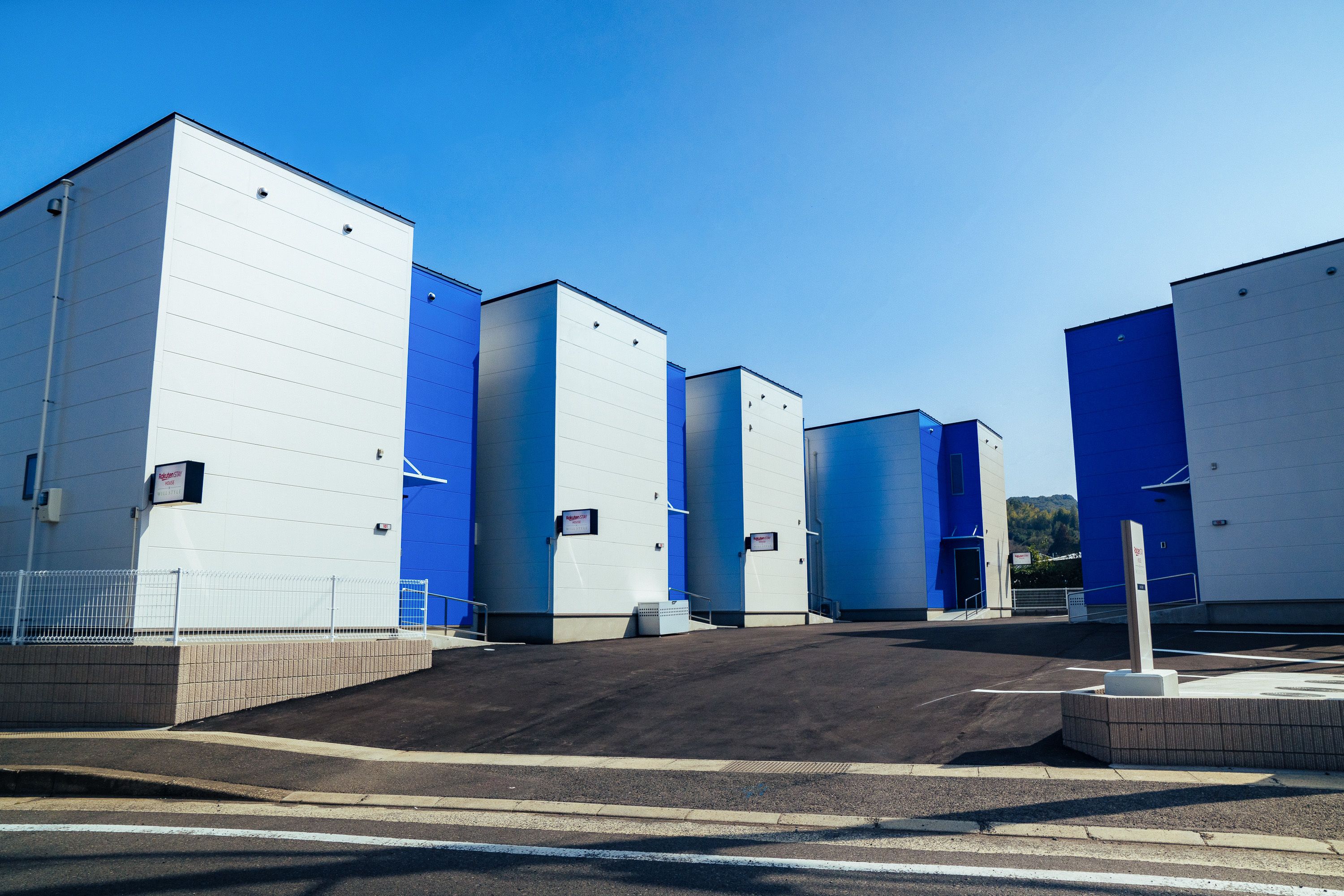 A large industrial building with multiple sections, each with a blue and white exterior.