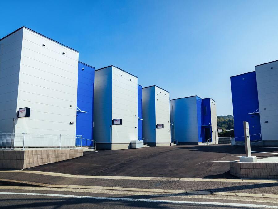 A large industrial building with multiple sections, each with a blue and white exterior.
