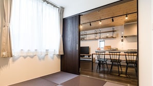 A modern interior with a dining area, kitchen, and a large sliding door leading to another room. - Rakuten STAY HOUSE x WILLSTYLE SASEBO (Sasebo)