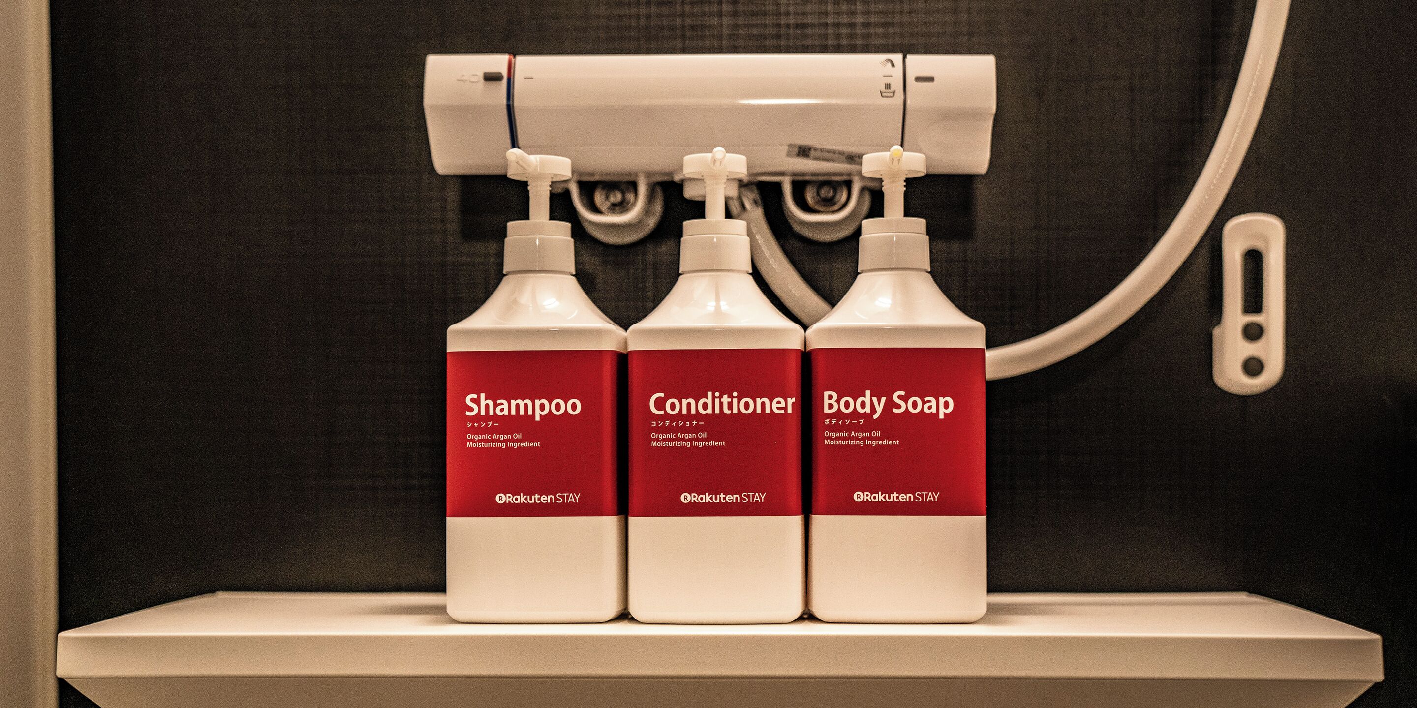 Tres botellas de champú, acondicionador y jabón de baño sobre una estantería.