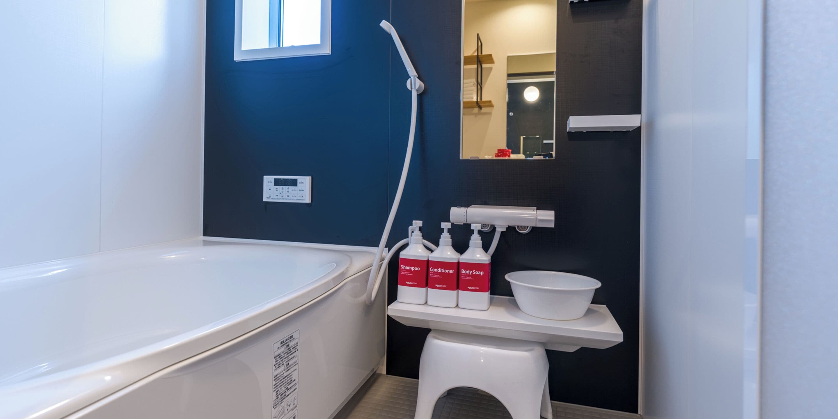 Un baño moderno con bañera, ducha y tocador con artículos de aseo.