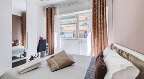 A bedroom with a bed, a desk, and a view of the outside. - Guest House Mr Brown (Rome)