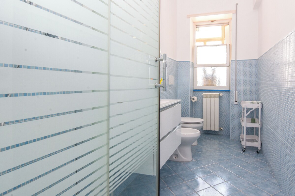 A bathroom with a toilet, a sink, and a window.