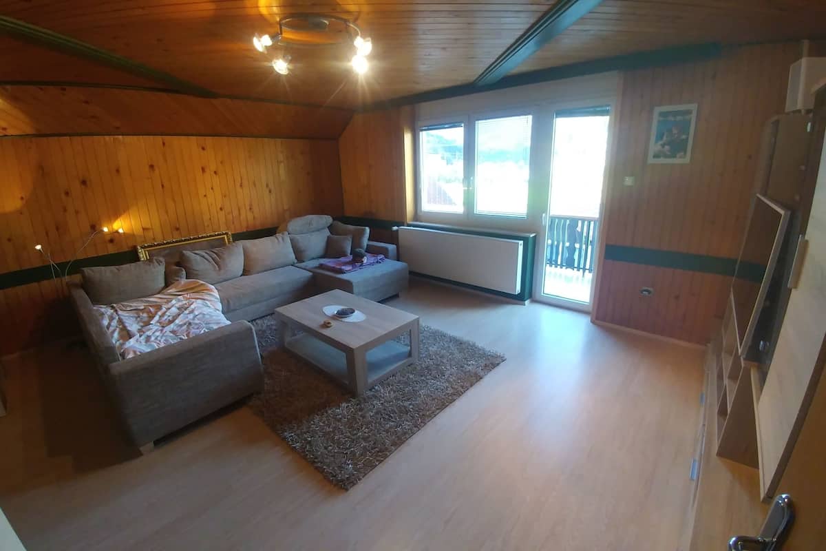A cozy room with a sofa, a small table, and a window.