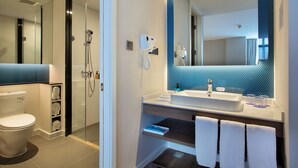 A modern bathroom with a glass shower enclosure, a large mirror, and a vanity with a sink and towel rack. - Holiday Inn Express Guilin City Center by IHG (Guilin)