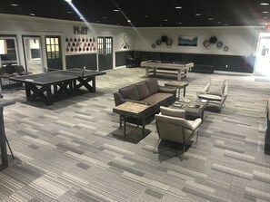 A room with a pool table, billiards, a sofa, and a ping pong table. - Hillside Crossing Nashville (Nashville)